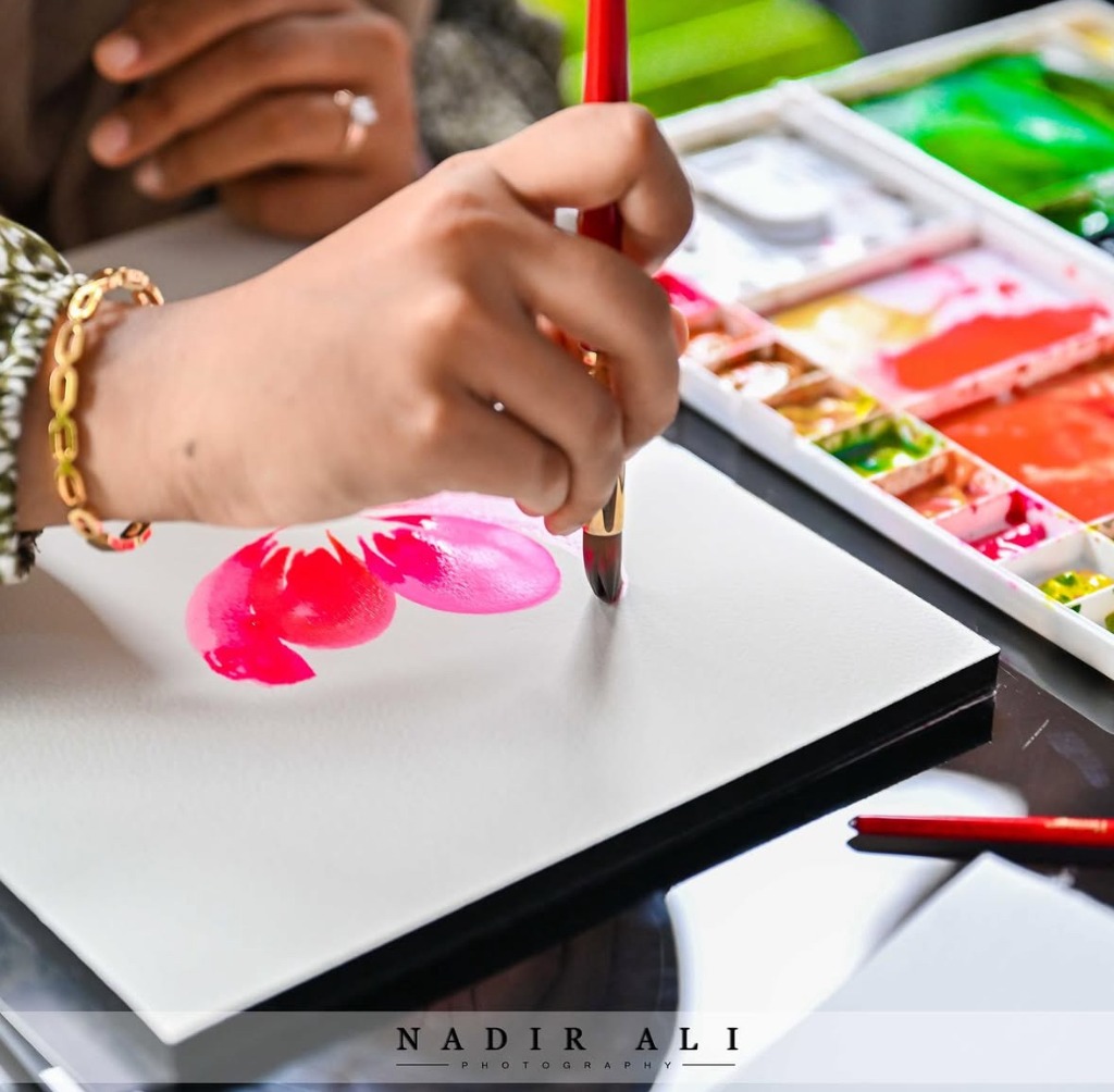 Celine Rahim painting delicate watercolour florals on high-quality archival paper in her studio